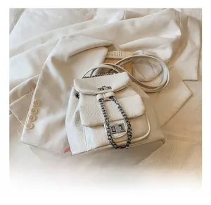Detail of cream mini chain backpack showing lychee texture leather and silver buckle