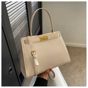 Detail of cream white leather Kelly bag with gold twist lock and adjustable shoulder strap