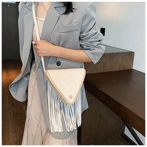 Détail du sac bandoulière triangulaire blanc cassé avec de longues franges en cuir PU grainé