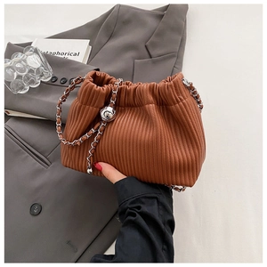 Close-up of brown pleated bucket bag with silver chain strap and heart charm detail
