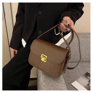 Dettaglio borsa a tracolla in pelle marrone con elegante chiusura a scatto rettangolare dorata