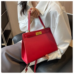 Classic red matte leather handbag with gold metal twist lock shown on a model