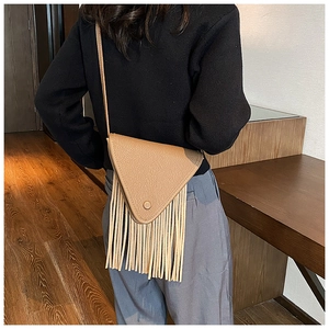 Détail du sac triangle kaki avec de longues franges fluides et une texture de cuir grainé