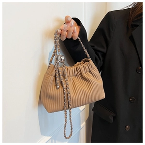 Detail of khaki pleated bucket bag with silver chain handle and metallic ball charm