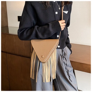 Détail d'un sac bandoulière triangulaire marron avec de longues franges et cuir texturé