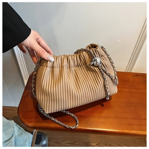 Detail of khaki pleated bucket bag with chain strap and silver metal ball charm