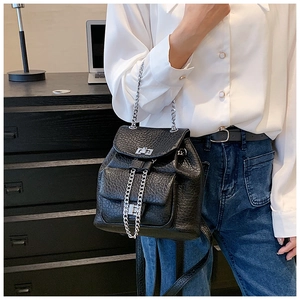 Close-up of litchi textured black leather backpack with silver chain and metal turn lock