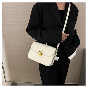 Borsa a tracolla in pelle bianca con fibbia dorata indossata da modella in tailleur