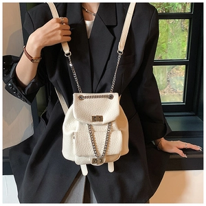 Detail of off-white crocodile embossed backpack with silver chain and twist lock