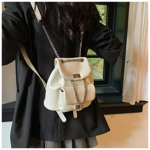 Close-up of white mini backpack featuring microfiber leather texture and silver chain strap
