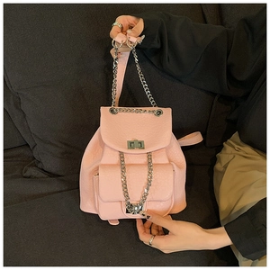 Detail view of pink leather backpack with silver chain straps and stylish metal turn lock