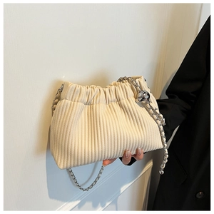 Detail of off-white pleated bucket bag featuring silver metal chain and ball ornament