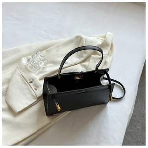 Detailed view of the black leather kelly bag with gold clasp and interior structure