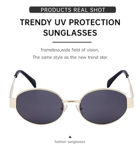 Detail of trendy oval sunglasses featuring thin gold metal frames and dark grey lenses