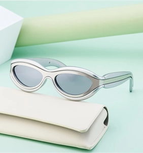 Dettaglio di occhiali da sole cat-eye futuristici su una custodia in pelle bianca