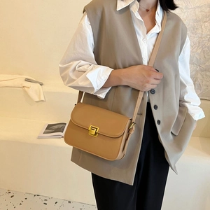 Borsa a tracolla marrone minimalista con fibbia dorata indossata da modella in outfit