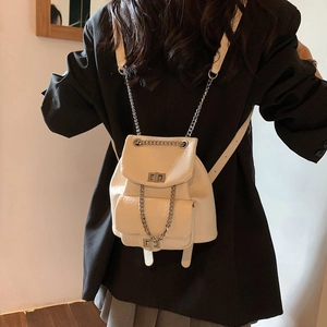 Fashionable off-white mini leather backpack with silver chain straps and turn-lock detail