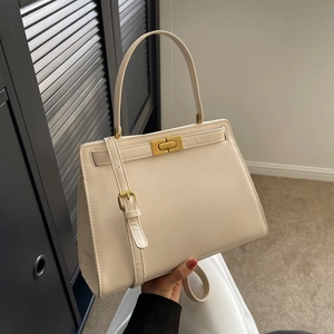 Chic cream trapezoid satchel with gold twist lock and adjustable shoulder strap