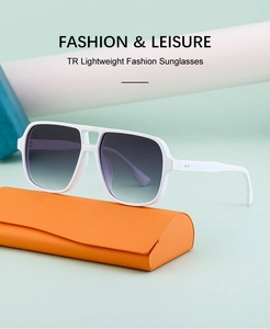 Detail of white aviator sunglasses with gradient lenses next to orange leather case