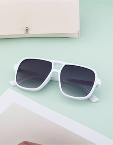 Detailed macro view of white pilot sunglasses with double bridge and gradient lenses