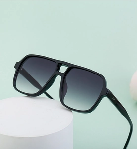 Detail of vintage double-bridge sunglasses with black thick frames and gray gradient lenses