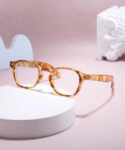 Detail view of tortoiseshell round eyeglass frames on an artistic display stand