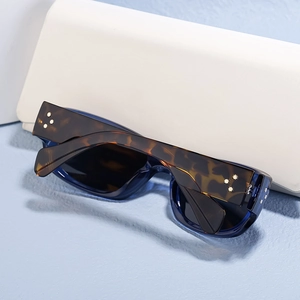 Detail view of polarized sunglasses with blue frames and tortoiseshell star rivet temples
