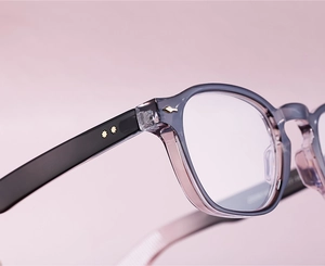 Close-up of blue translucent acetate frame with gold star studs on black temples