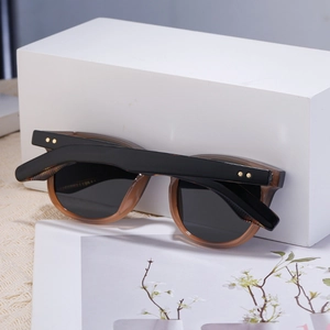 Détail de lunettes de soleil carrées rétro avec rivets étoiles dorés et monture