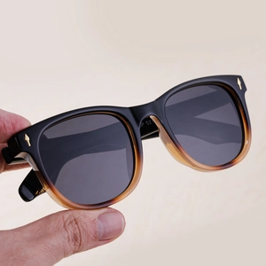 Gros plan des lunettes polarisées carrées avec monture dégradée du noir à l'ambre et rivets