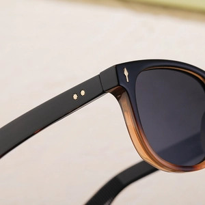 Détail de lunettes de soleil polarisées écaille avec rivets étoile dorés et charnière métal