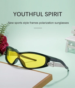 Detail of sports sunglasses with black frame and yellow lenses against a green background