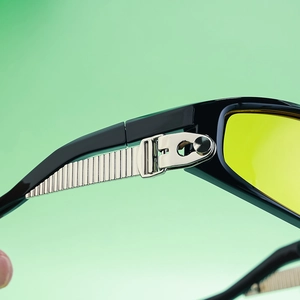 Detail of silver multi-layer metal hinges on sports sunglasses with yellow lenses