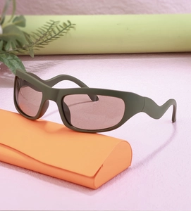 Detail of olive green Y2K sports sunglasses with zigzag temples and orange triangular case