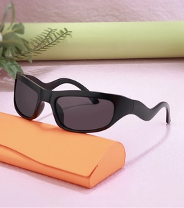 Detail of Y2K sports sunglasses featuring wavy temples and a matte black frame with case