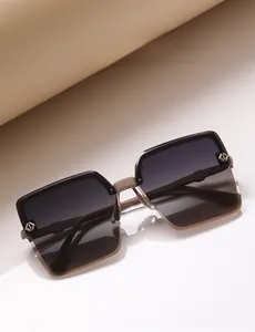 Détail de lunettes de soleil oversize avec verres dégradés et accents dorés