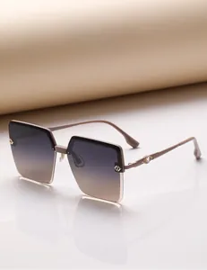 Détail de lunettes de soleil oversize avec monture champagne et verres dégradés