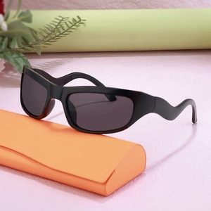 Y2K sporty sunglasses with black wrap frame and wave arms on an orange case