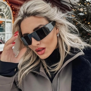 Close-up of polarized oversized black wrap-around sunglasses worn outdoors in snowy background
