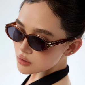 Side view of woman wearing amber brown square polarized sunglasses with gold metal temple detail