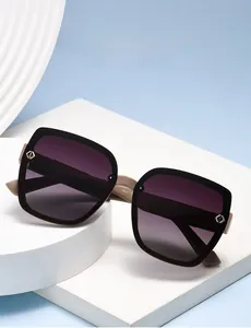 Detail of square polarized sunglasses with purple gradient lenses and gold accents