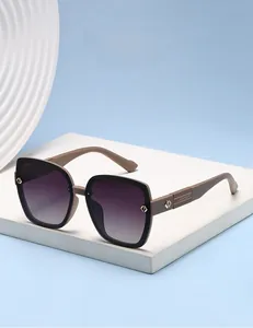 Detail of oversized black and beige sunglasses with purple gradient lenses and metal logo