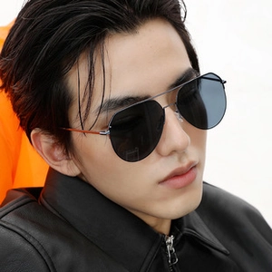 Detail of polarized aviator sunglasses featuring dark metal frames and orange temple accents
