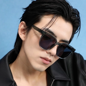 Close-up of polarized square sunglasses with grey translucent frames on a fashion model