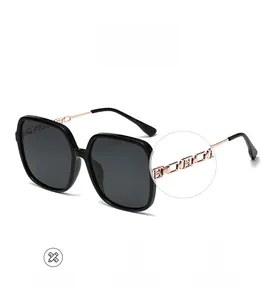 Close-up of polarized square sunglasses with stylish gold chain metal temples detail