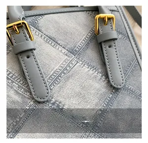 Close-up of golden metal buckle and blue denim plaid texture on a small square bag