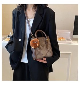 Detail of color-block crossbody bag with houndstooth pattern and a cute brown plush bear