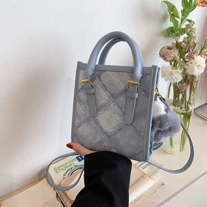 Light blue quilted denim small square bag with plush ball pendant and dual handles