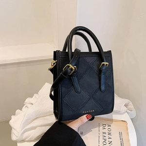 Minimalist black quilted square handbag with gold handles and adjustable shoulder strap