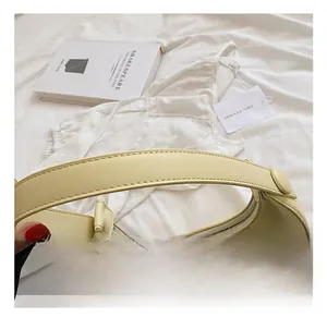 Detail of a cream yellow hobo bag showing its smooth leather texture and silver zipper